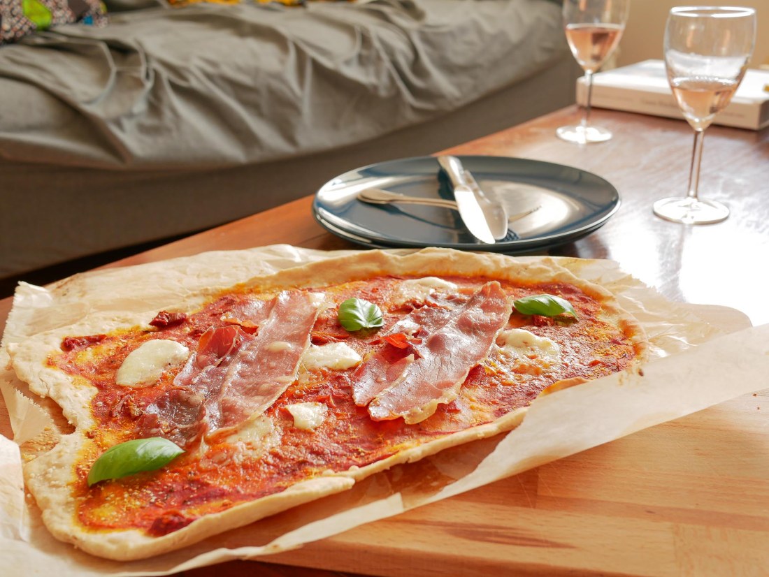Pizza posée sur une table avec des verres de vin